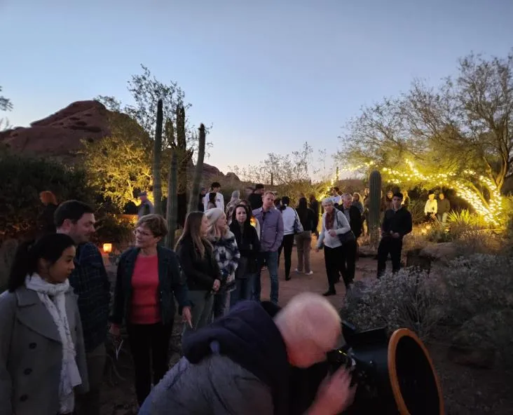 A large crowd gathered at dusk among lit cacti for a PAS Star Tours event